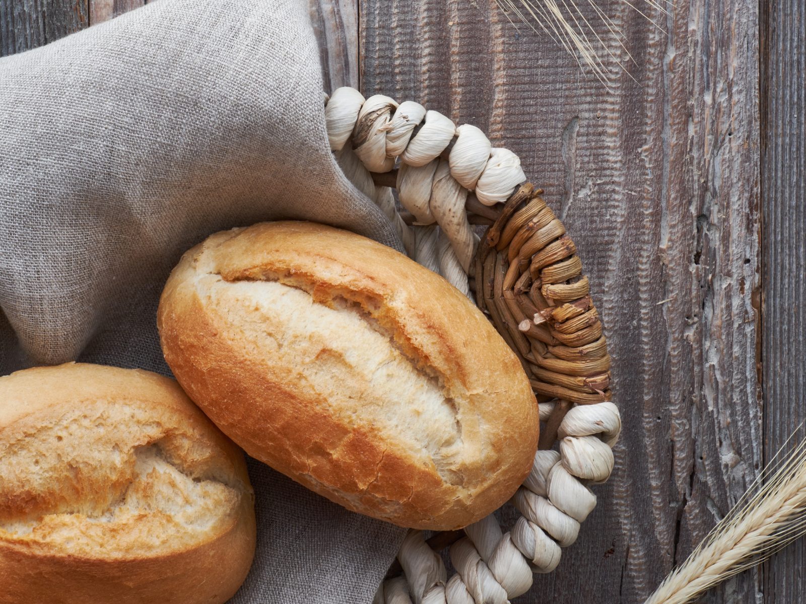 Bread in a basket on a wooden table (Lord’s Supper preparation)